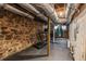 Unfinished basement with stone walls, exposed ductwork, and rubber flooring, offering ample storage or workspace at 1590 Johnson Ne Rd, Atlanta, GA 30306