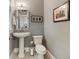 Small bathroom with gray walls, toilet, pedestal sink, and marble-patterned flooring at 1590 Johnson Ne Rd, Atlanta, GA 30306
