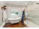 Bright bathroom featuring a soaking tub, and a glass shower with backyard views at 1590 Johnson Ne Rd, Atlanta, GA 30306