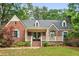 Charming brick home with stone accents, a covered porch, blue shutters, and a well-maintained lawn at 1590 Johnson Ne Rd, Atlanta, GA 30306