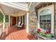 Covered front porch featuring brick flooring, stone accents, and comfortable seating, creating a welcoming entrance at 1590 Johnson Ne Rd, Atlanta, GA 30306