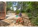 Charming stone patio featuring a picnic table and walkway to a detached garage, surrounded by lush landscaping at 1590 Johnson Ne Rd, Atlanta, GA 30306