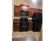 Kitchen featuring dark wood cabinets, black appliances, and gray countertops at 2118 Burns View Ln, Lawrenceville, GA 30044