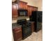 Kitchen with dark wood cabinets, black appliances, and gray countertops at 2118 Burns View Ln, Lawrenceville, GA 30044