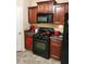 Contemporary kitchen featuring black appliances, wooden cabinets, and gray countertops at 2118 Burns View Ln, Lawrenceville, GA 30044