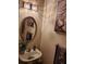 Chic powder room featuring a pedestal sink, oval mirror, and decorative accents at 2118 Burns View Ln, Lawrenceville, GA 30044