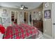 Cozy bedroom featuring a red plaid bedspread, ceiling fan, and decorative sports memorabilia at 2225 Independence Ln, Buford, GA 30519
