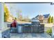 An outdoor kitchen with stainless steel appliances including a built-in grill and stone surround on a patio at 2225 Independence Ln, Buford, GA 30519