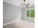 Serene bedroom featuring neutral walls, carpet, a ceiling fan, and a view of the trees at 2740 Cezanne Ln, Cumming, GA 30041