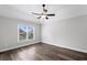Spacious bedroom with hardwood floors, and a window overlooking the backyard at 2740 Cezanne Ln, Cumming, GA 30041