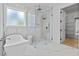 Bright bathroom with a glass shower, free-standing tub, and marble tile at 400 Auburn Rd, Auburn, GA 30011