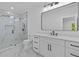 Bathroom featuring double sinks, shower tub, glass door, recessed lighting, and marble floors at 400 Auburn Rd, Auburn, GA 30011