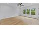 Bright bedroom with hardwood floors, ceiling fan, and windows looking out onto a wooded area at 400 Auburn Rd, Auburn, GA 30011