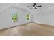 Bright bedroom with light hardwood floors, ceiling fan, and natural light from two large windows at 400 Auburn Rd, Auburn, GA 30011