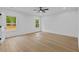 Sunlit bedroom featuring hardwood floors, ceiling fan, and green view from the windows at 400 Auburn Rd, Auburn, GA 30011
