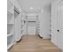 Spacious walk-in closet with custom shelving and hardwood floors at 400 Auburn Rd, Auburn, GA 30011