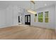 Bright dining room features hardwood floors, large windows, black french doors, and a modern gold light fixture at 400 Auburn Rd, Auburn, GA 30011