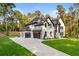 Stunning white brick two-story home with black trim, a two car garage and lush green lawn at 400 Auburn Rd, Auburn, GA 30011