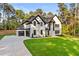Beautiful white brick two-story home with black trim, two car garage and green lawn at 400 Auburn Rd, Auburn, GA 30011
