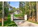 View of gated entrance and long drive to a stately, modern farmhouse nestled in a wooded lot at 400 Auburn Rd, Auburn, GA 30011
