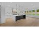Bright kitchen featuring a large island with a waterfall countertop and modern lighting fixtures at 400 Auburn Rd, Auburn, GA 30011