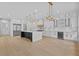 Bright kitchen with white cabinetry, marble countertops, stainless steel appliances, and modern pendant lighting at 400 Auburn Rd, Auburn, GA 30011