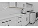Modern laundry room with white cabinets, quartz countertops, stainless steel sink, and new washer and dryer at 400 Auburn Rd, Auburn, GA 30011