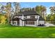 Back of the house featuring a patio, expansive green lawn, and modern design with black-framed windows at 400 Auburn Rd, Auburn, GA 30011