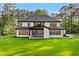 Stunning rear exterior of the home with a covered patio and large windows overlooking the lush green lawn at 400 Auburn Rd, Auburn, GA 30011