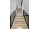 Stylish staircase with wooden steps, black iron railing, and recessed lighting at 400 Auburn Rd, Auburn, GA 30011
