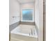 A pristine white bathtub is set beneath a window, providing a serene bathing experience at 5331 Tuscany Dr, Douglasville, GA 30135