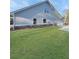 Side of a home with grey siding, stone accents, and a well manicured lawn at 5331 Tuscany Dr, Douglasville, GA 30135