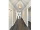Long hallway illuminated by a pendant light and featuring wood-look flooring at 5331 Tuscany Dr, Douglasville, GA 30135