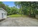 Large, grassy backyard with mature trees, a white outbuilding, and a fenced perimeter at 581 Taylor Se Dr, Smyrna, GA 30080