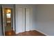 Bedroom featuring light gray walls and gleaming hardwood floors, closet with paneled doors at 162 Odyssey Turn, Conyers, GA 30012