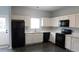 Bright kitchen features white cabinets and black appliances at 162 Odyssey Turn, Conyers, GA 30012