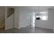 Open-concept living space with modern gray flooring and staircase leading upstairs at 162 Odyssey Turn, Conyers, GA 30012