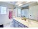 Bright bathroom features double sinks, a large mirror, and a white tiled floor at 1812 Riverton Dr, Suwanee, GA 30024