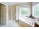 Bright bathroom features a soaking tub, a shower, and double sinks at 1812 Riverton Dr, Suwanee, GA 30024
