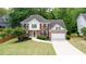 Aerial view of a well-manicured two-story home with a two-car garage and mature landscaping at 1812 Riverton Dr, Suwanee, GA 30024