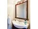 Cozy powder room with a pedestal sink, decorative mirror, and neutral wall color at 1812 Riverton Dr, Suwanee, GA 30024