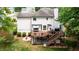 Rear exterior view of home with a spacious wooden deck, swing, stairs, and a well-maintained backyard at 1812 Riverton Dr, Suwanee, GA 30024