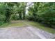 A tranquil backyard featuring grass and a stone pathway in a mature tree-filled environment at 2284 Dauphine St, East Point, GA 30344