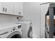 Practical laundry room equipped with modern washer and dryer units and ample storage at 2284 Dauphine St, East Point, GA 30344