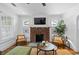 Cozy living room featuring a brick fireplace, hardwood floors, and bright natural light at 2284 Dauphine St, East Point, GA 30344