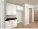 Bright kitchen area with white cabinets, black countertops, and modern backsplash at 5321 Tuscany Dr, Douglasville, GA 30135