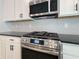 A close up shot of stainless steel gas stove with white cabinets and herringbone backsplash at 5321 Tuscany Dr, Douglasville, GA 30135