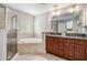 Bright bathroom features a soaking tub, a walk-in shower, and a double vanity with granite countertops at 75 High Top Ln, Atlanta, GA 30328