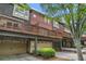 Townhome exterior with brick facade, garages, and wooden balconies, set against a green, leafy backdrop at 75 High Top Ln, Atlanta, GA 30328