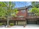 Townhome exterior featuring brick, balconies, and garages, framed by lush greenery and blue skies at 75 High Top Ln, Atlanta, GA 30328